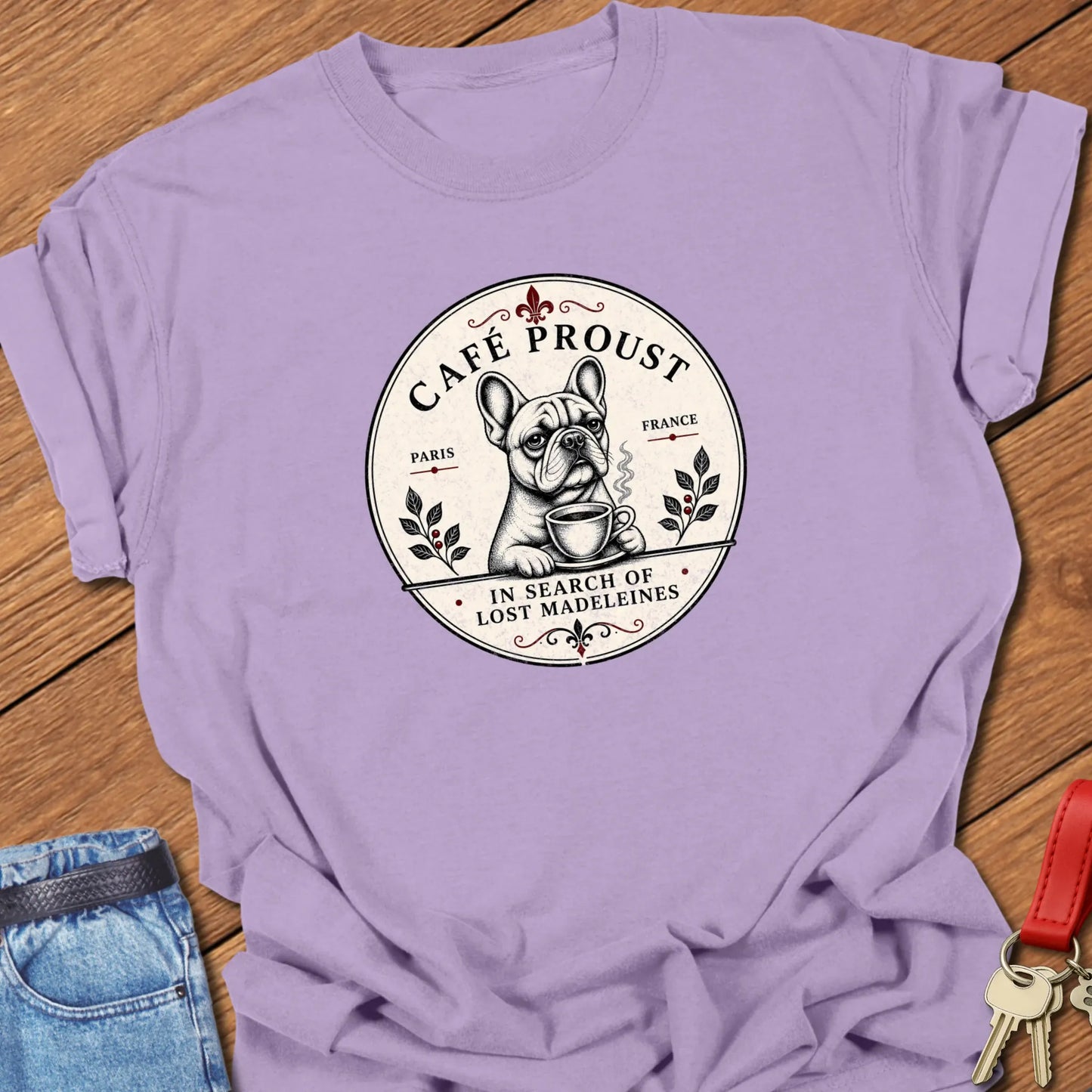 Café Proust French Bulldog graphic t-shirt featuring the phrase "In Search of Lost Madeleines" with vintage Paris café artwork in Orchid color.