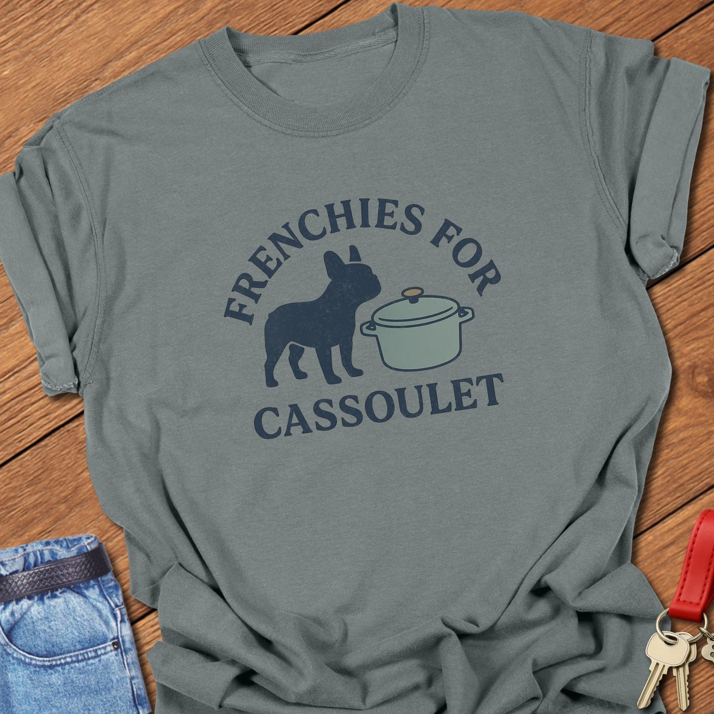 French bulldog humorous French food illustration with cassoulet pot graphic and bold typography printed on ivory Comfort Colors t shirt