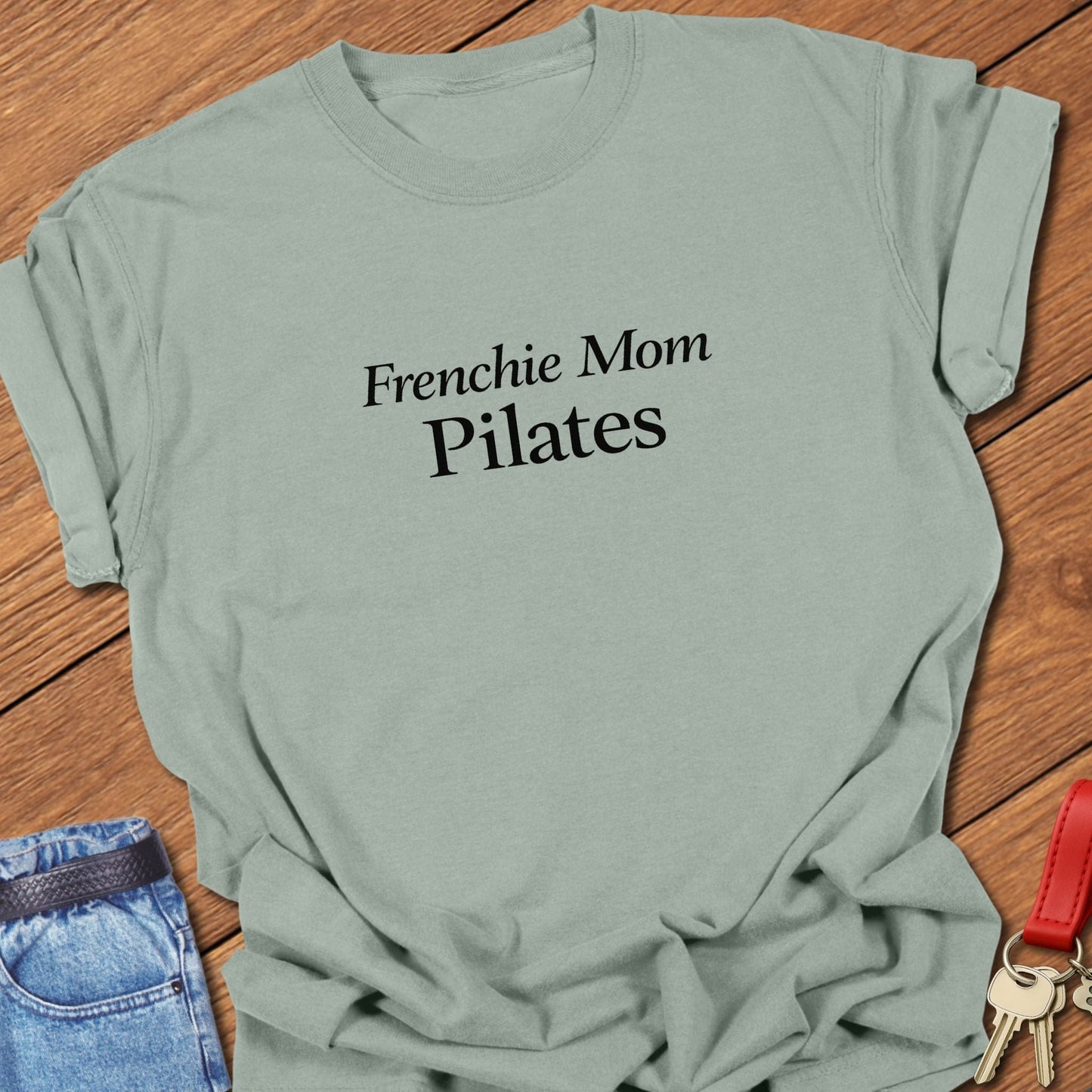 Frenchie Mom Pilates text design printed in black serif typography on a garment-dyed Comfort Colors 1717 t shirt in bay.