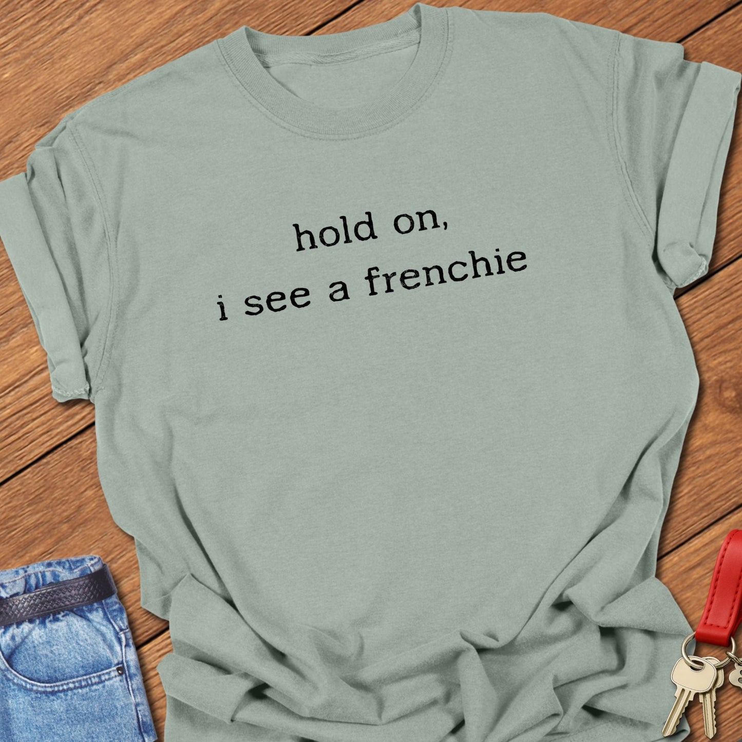French bulldog minimalist text design reading “hold on, i see a frenchie” printed on bay Comfort Colors t shirt