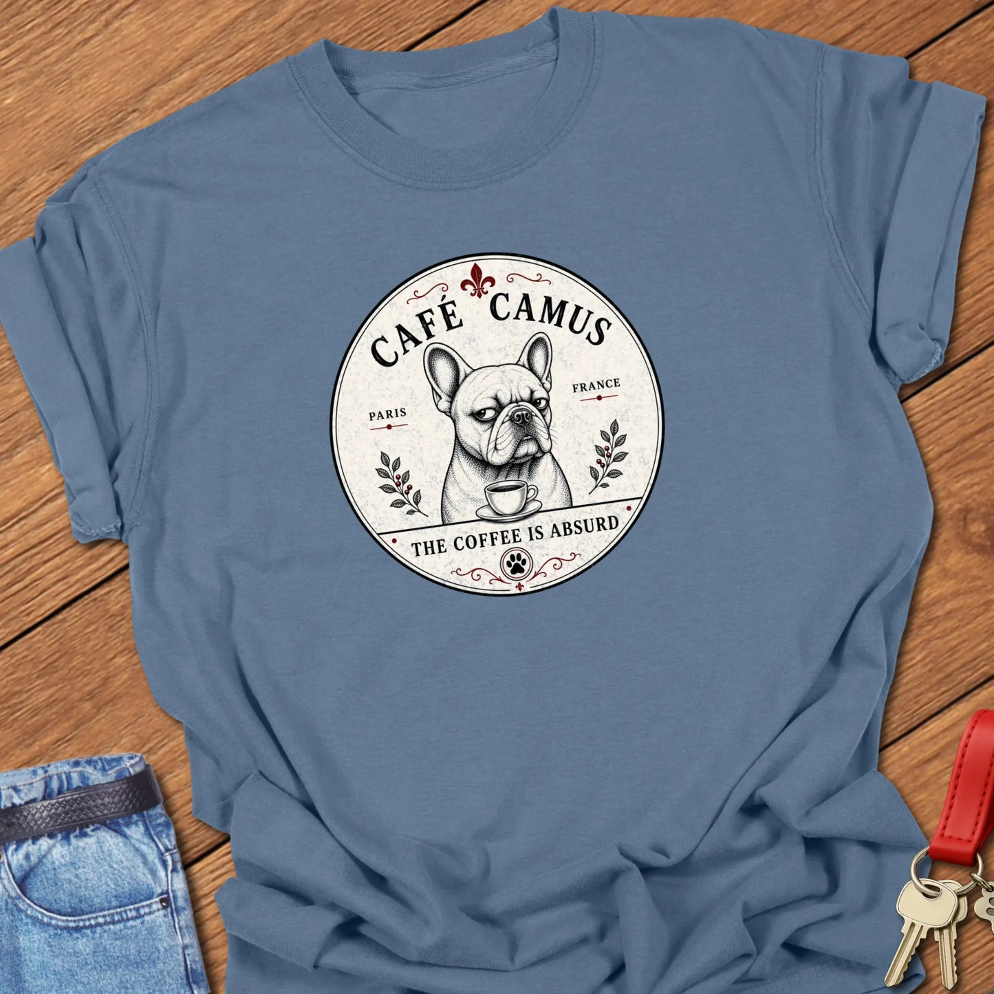 Absurd Coffee French Bulldog graphic t-shirt featuring Café Camus artwork and "The Coffee Is Absurd" slogan in Blue Jean color.