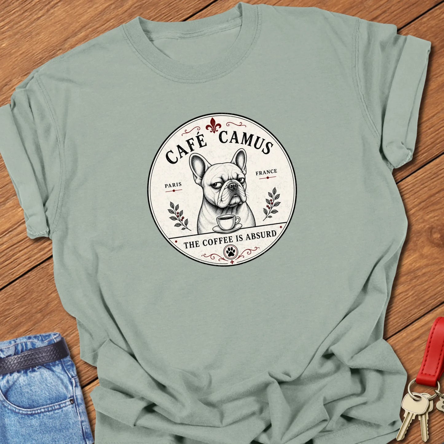 Absurd Coffee French Bulldog graphic t-shirt featuring Café Camus artwork and "The Coffee Is Absurd" slogan in Bay color.