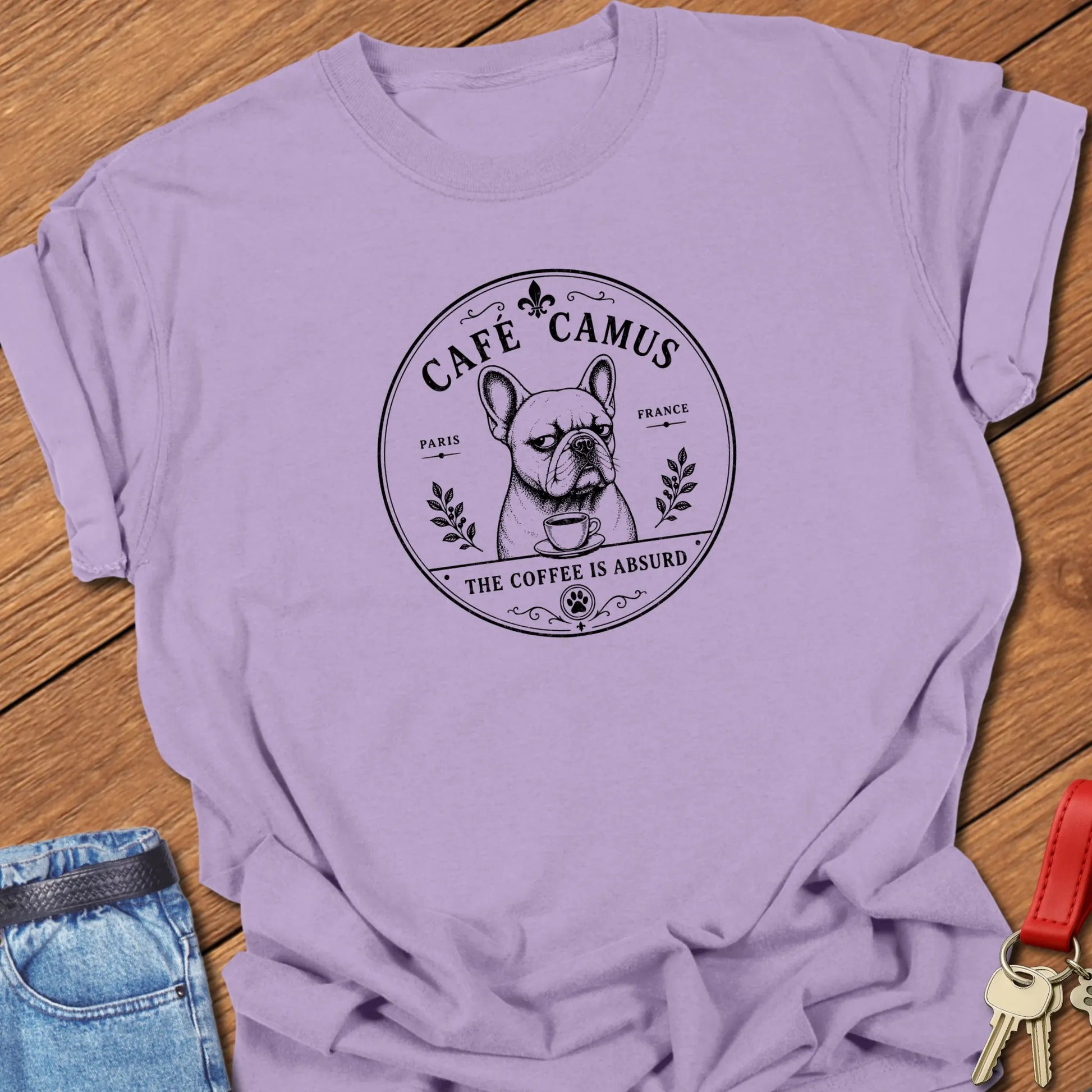 Café Camus French Bulldog literary coffee t-shirt featuring the slogan "The Coffee Is Absurd" in Orchid color with vintage Paris café-inspired artwork.