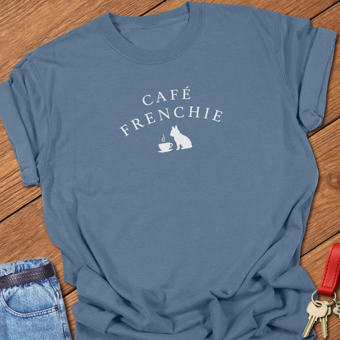 Café Frenchie French Bulldog graphic t-shirt in Comfort Colors Blue Jean featuring a coffee cup and Frenchie silhouette design in soft ivory ink.