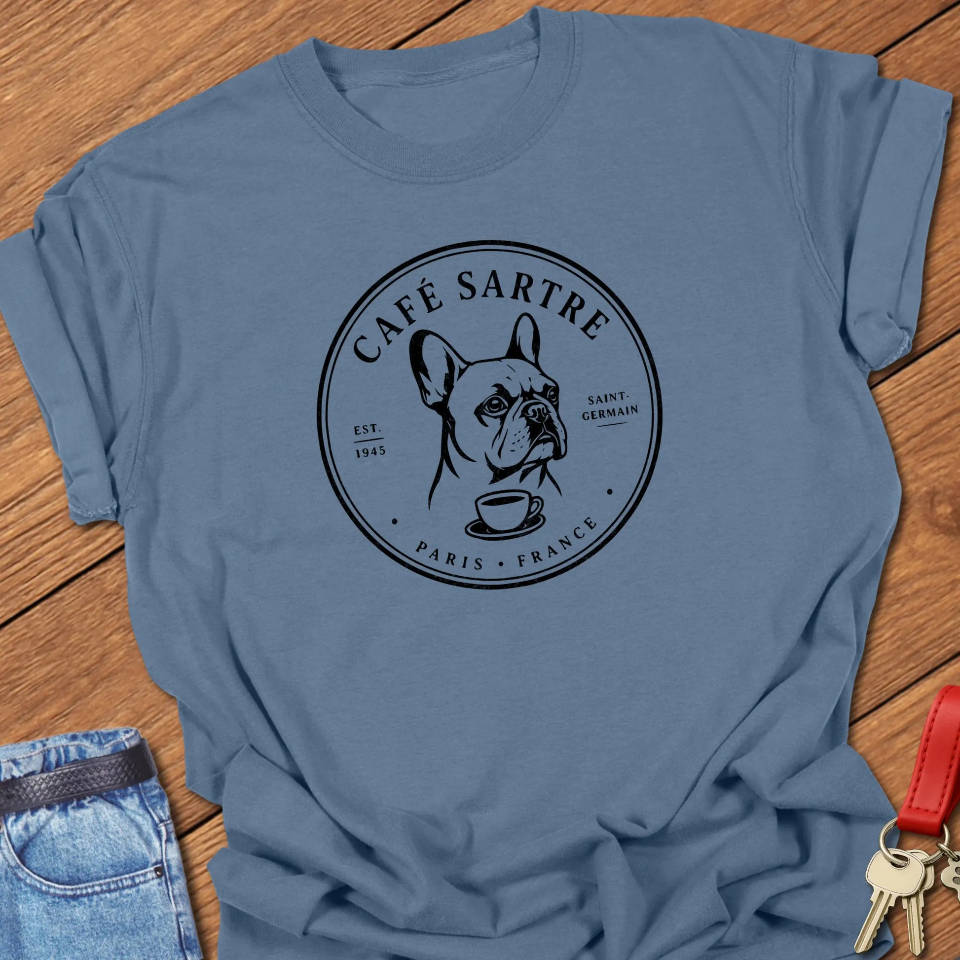 Café Sartre Paris French Bulldog graphic t-shirt featuring minimalist Saint-Germain café artwork and literary-inspired design in Blue Jean color.