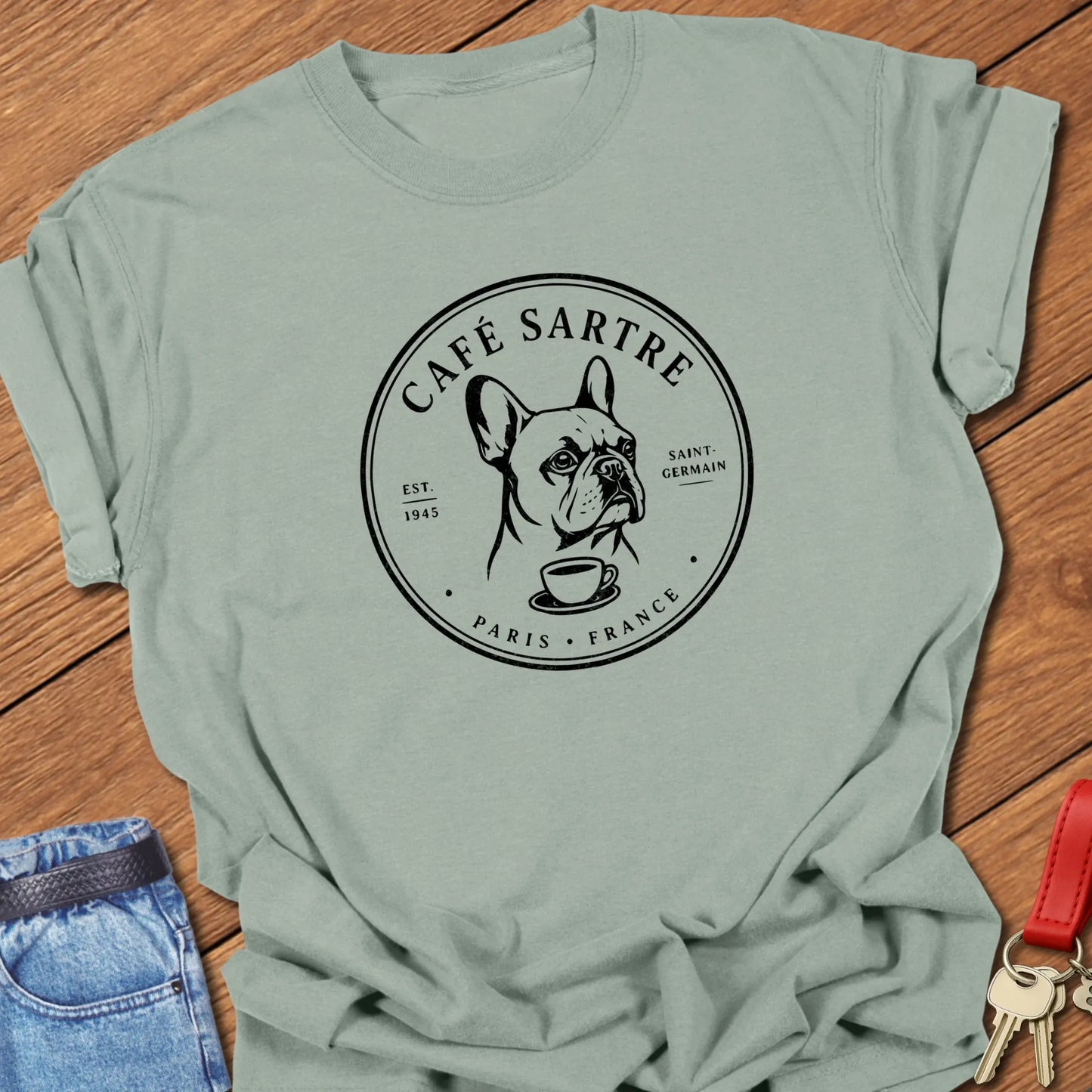 Café Sartre Paris French Bulldog graphic t-shirt featuring minimalist Saint-Germain café artwork and literary-inspired design in Bay color.