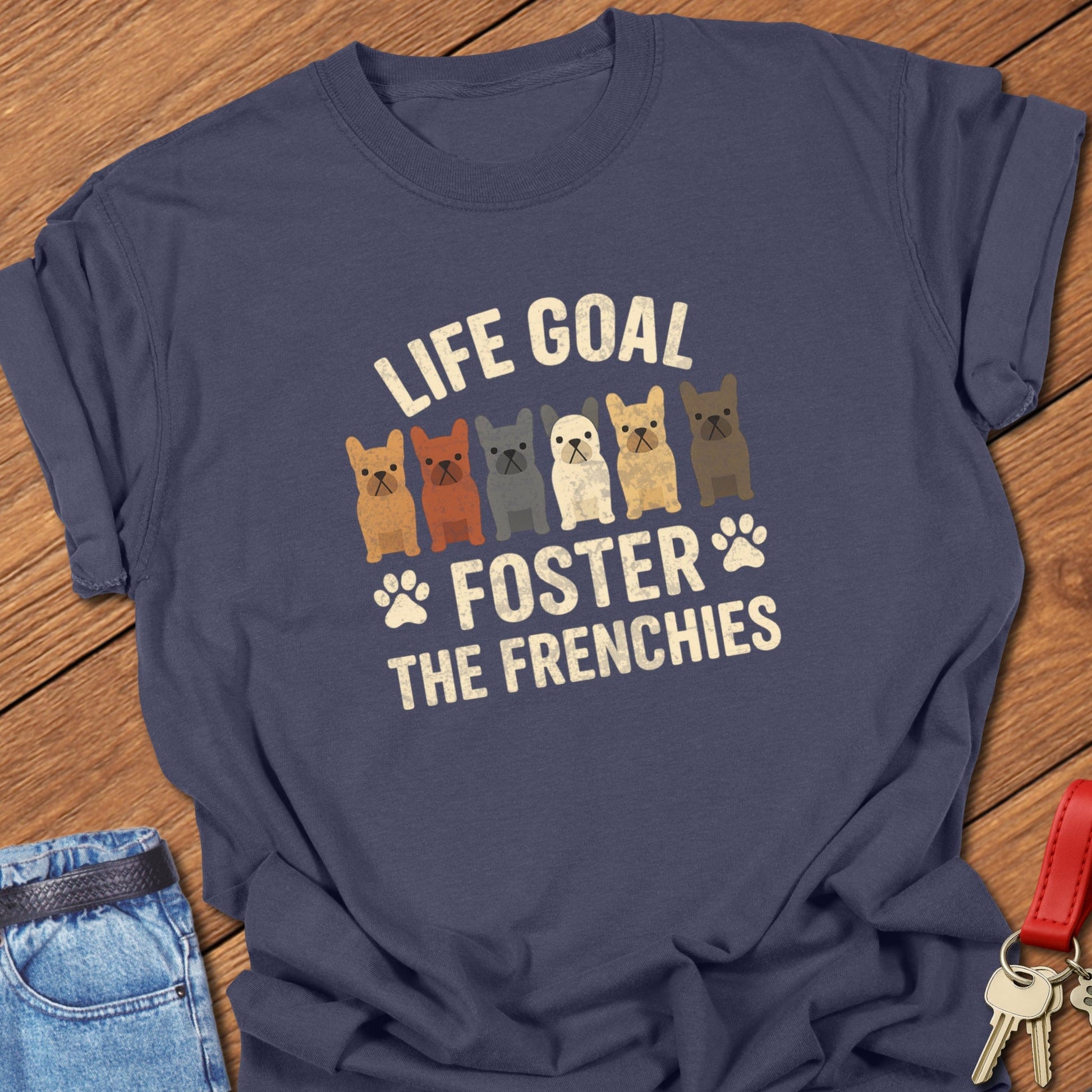 French bulldog foster illustration with multiple Frenchie graphics and bold life goal typography printed on navy Comfort Colors t shirt