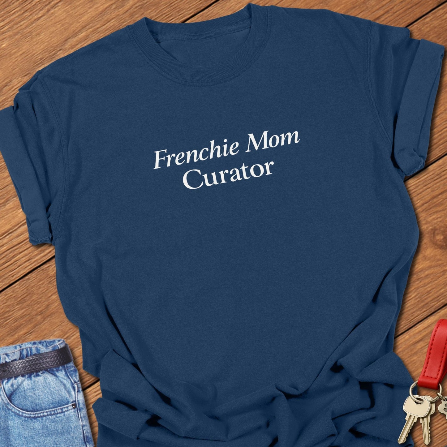 Minimalist serif text design reading “Frenchie Mom Curator” on garment-dyed Comfort Colors t shirt in true navy.
