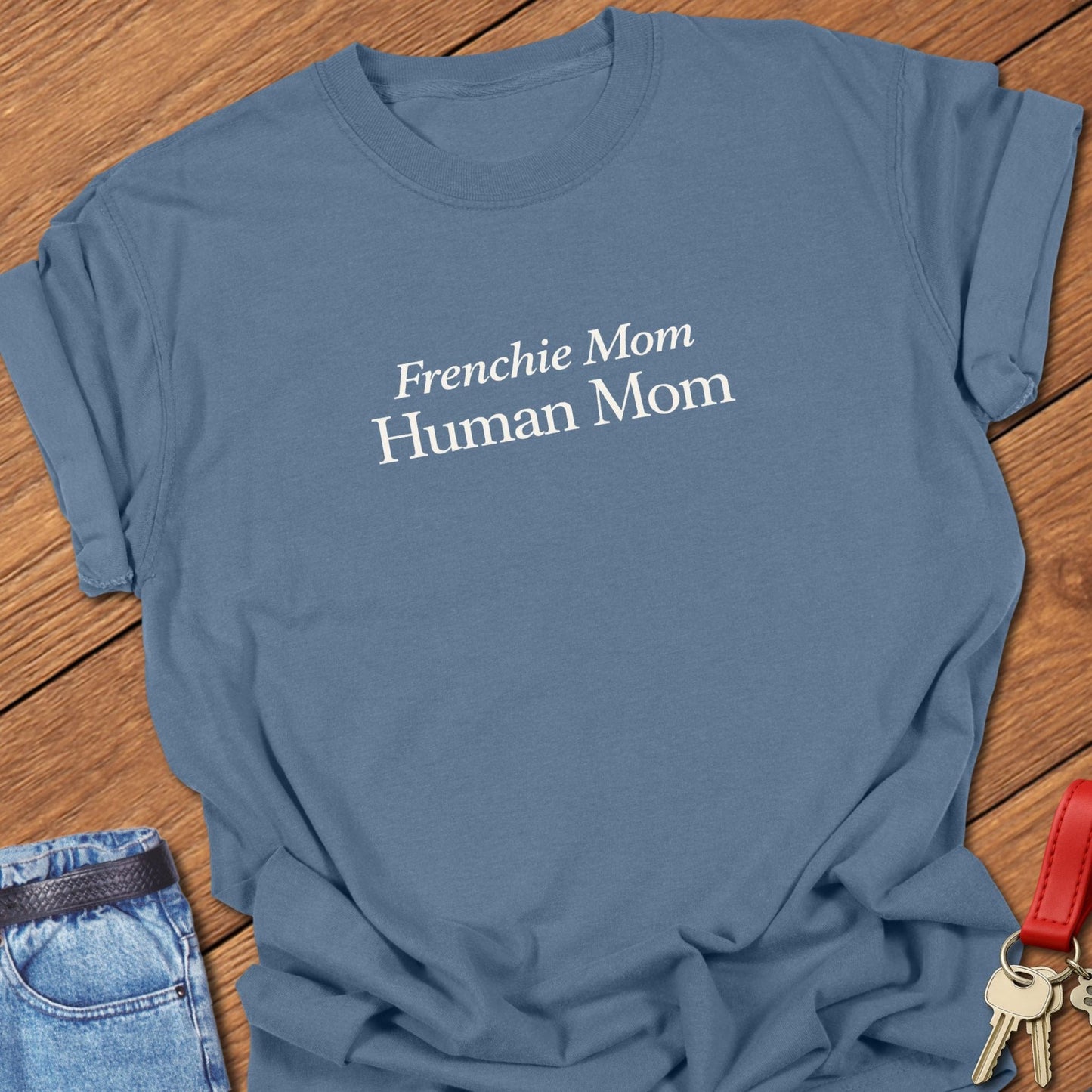 Comfort Colors garment-dyed Frenchie mom t shirt with ivory serif “Frenchie Mom Human Mom” typography on a blue jean tee, designed for women balancing motherhood and French bulldog life.
