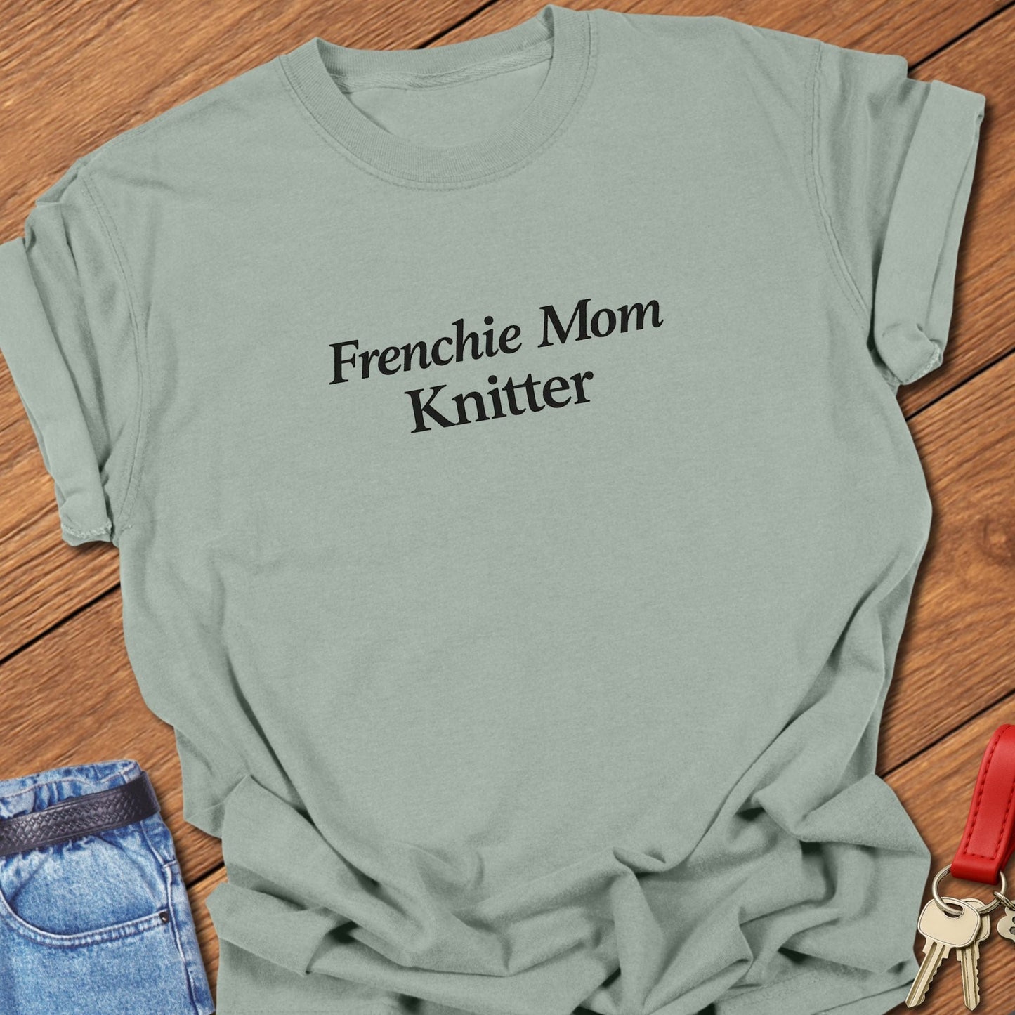Minimalist Frenchie Mom Knitter text design printed in solid black serif typography on a bay garment-dyed Comfort Colors T shirt
