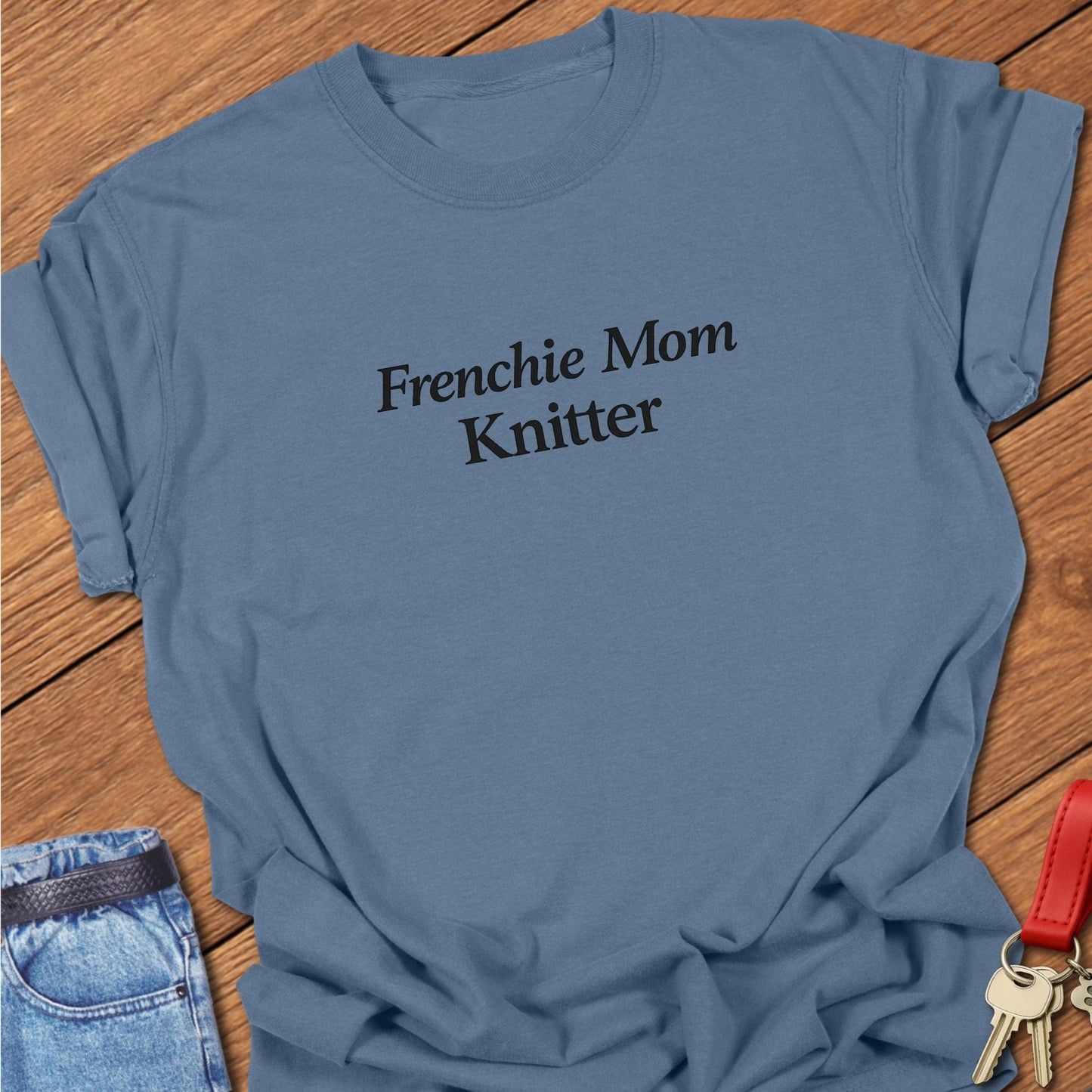 Minimalist Frenchie Mom Knitter text design printed in solid black serif typography on a blue jean garment-dyed Comfort Colors T shirt