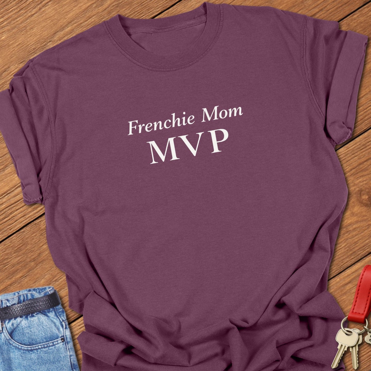 Bold minimalist text design reading “Frenchie Mom MVP” on garment-dyed Comfort Colors t shirt in berry.