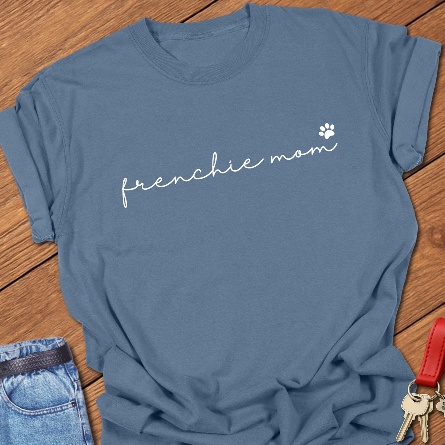 French bulldog minimalist script typography “frenchie mom” with small paw icon printed on blue jean Comfort Colors t shirt