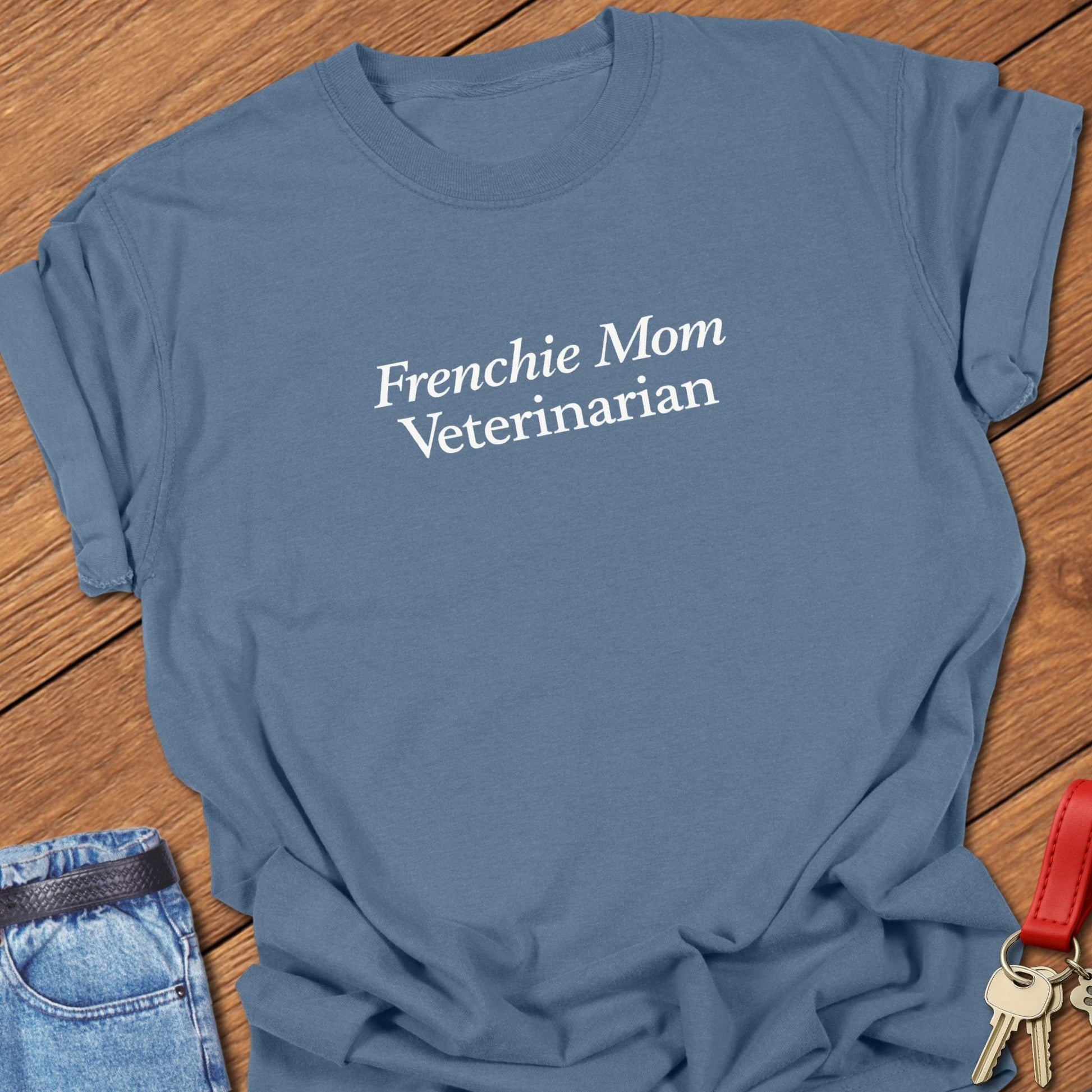 Minimalist serif text design reading “Frenchie Mom Veterinarian” on garment-dyed Comfort Colors t shirt in blue jean.