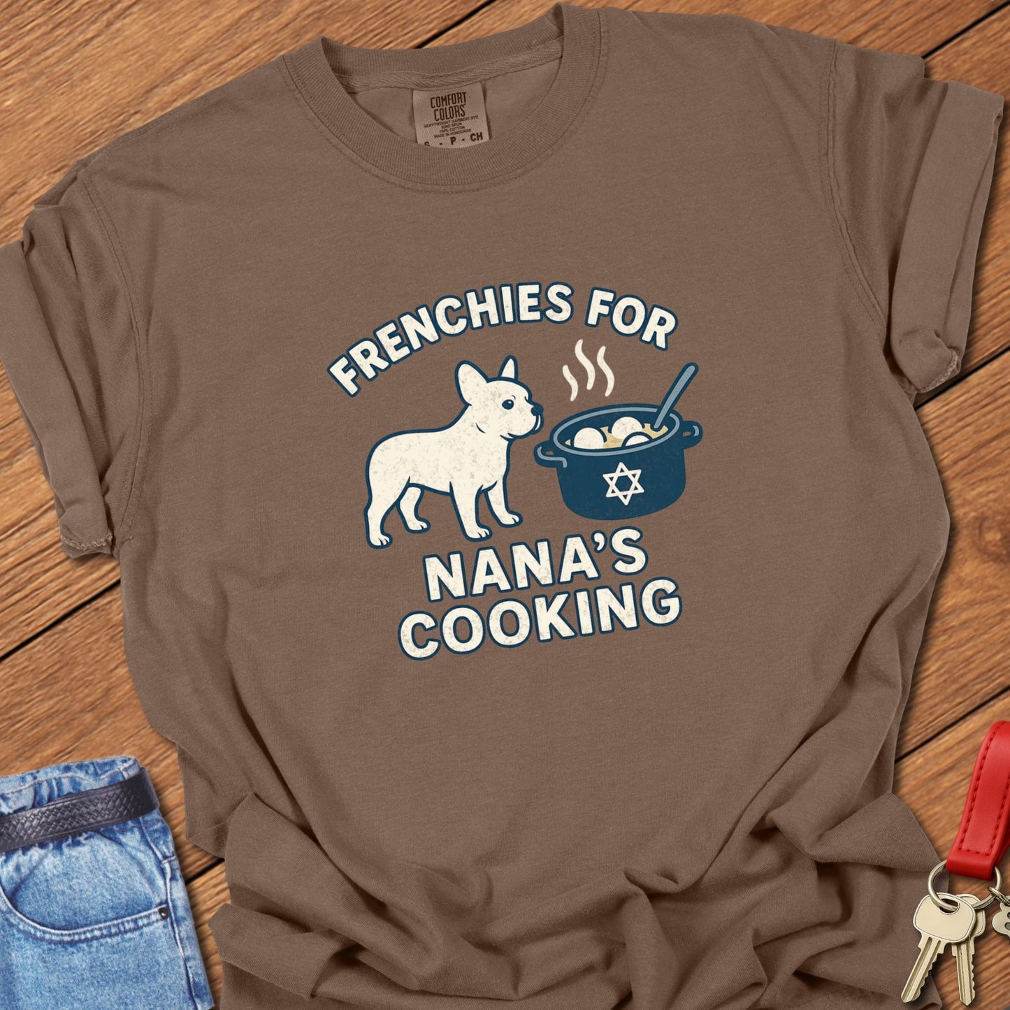 French bulldog humorous Jewish food illustration with Nana’s cooking pot graphic and playful slogan printed on espresso Comfort Colors t shirt
