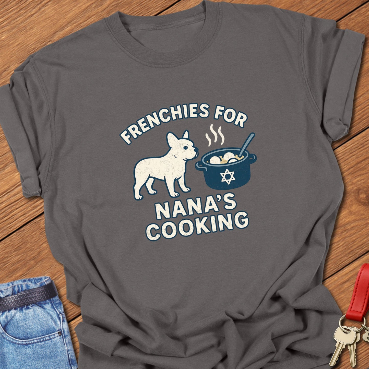 French bulldog humorous Jewish food illustration with Nana’s cooking pot graphic and playful slogan printed on pepper Comfort Colors t shirt
