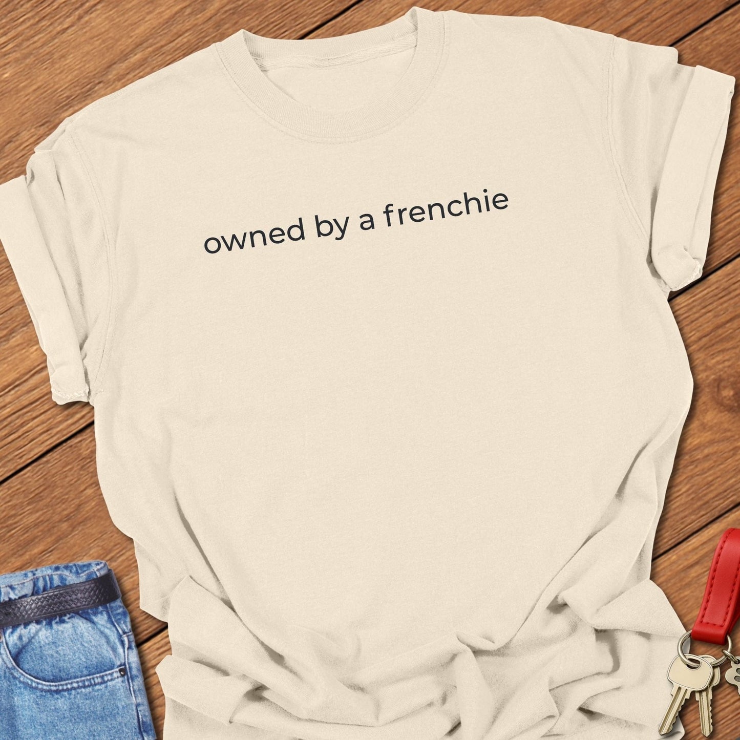 French bulldog owned by a frenchie text graphic printed on ivory Comfort Colors t shirt.