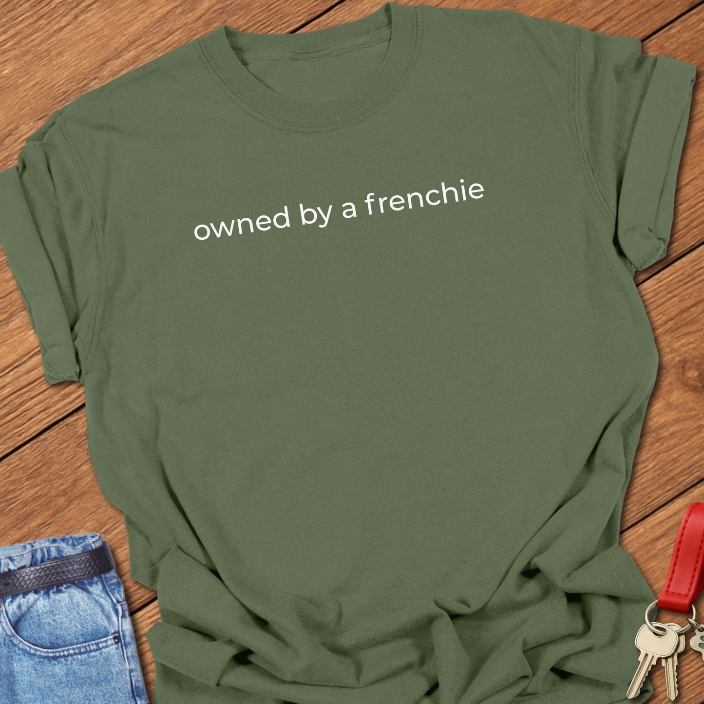 French bulldog owned by a frenchie text graphic printed on moss Comfort Colors t shirt.