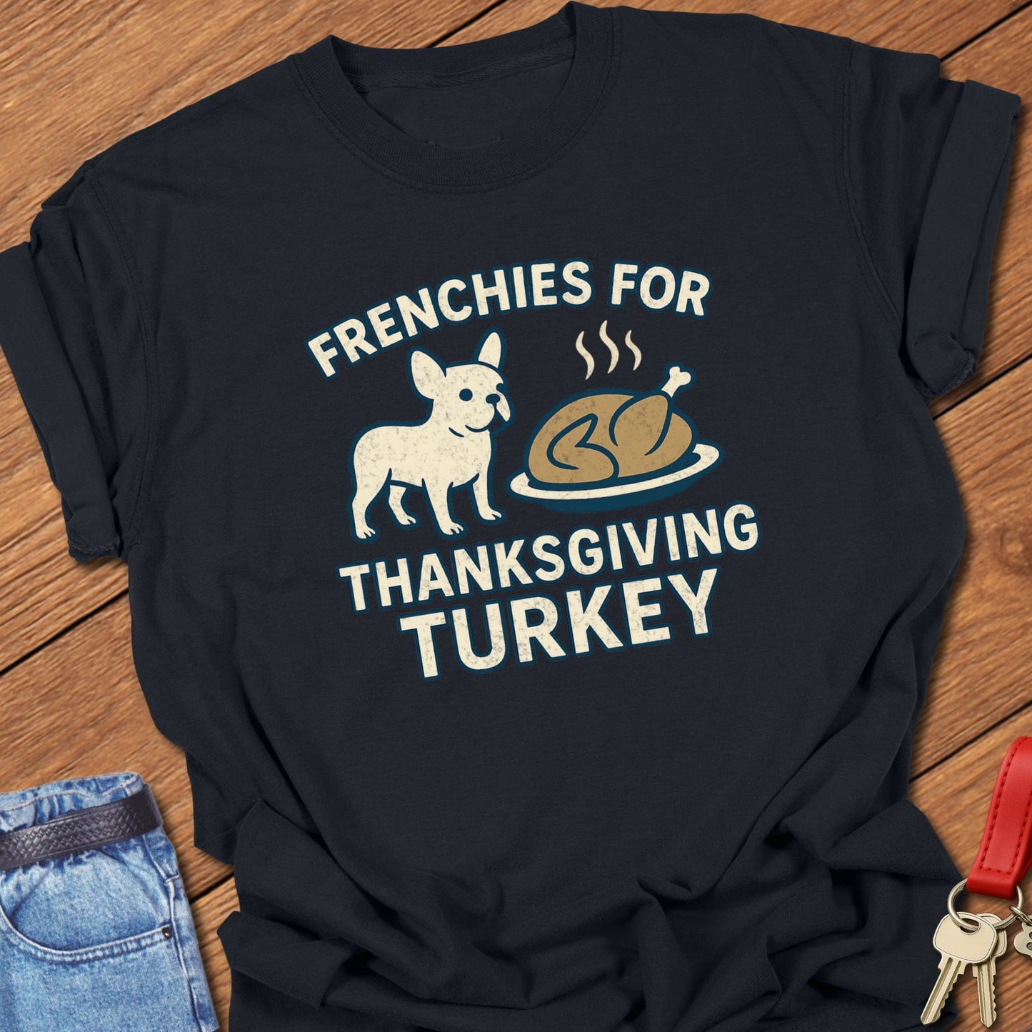 French bulldog Thanksgiving illustration with cartoon Frenchie and roasted turkey graphic printed on black Comfort Colors t shirt