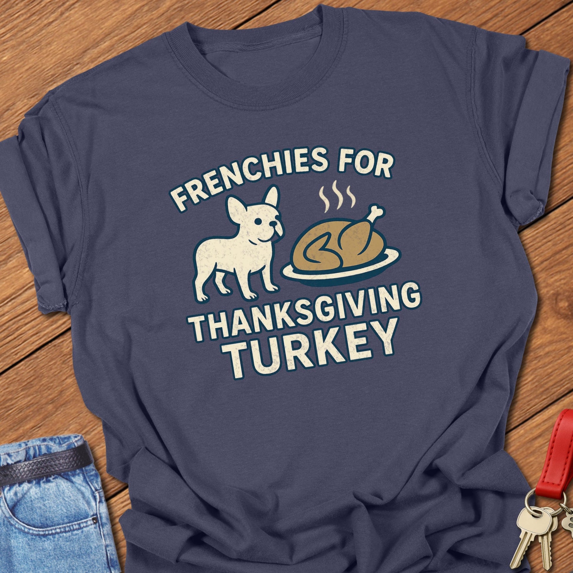French bulldog Thanksgiving illustration with cartoon Frenchie and roasted turkey graphic printed on navy Comfort Colors t shirt