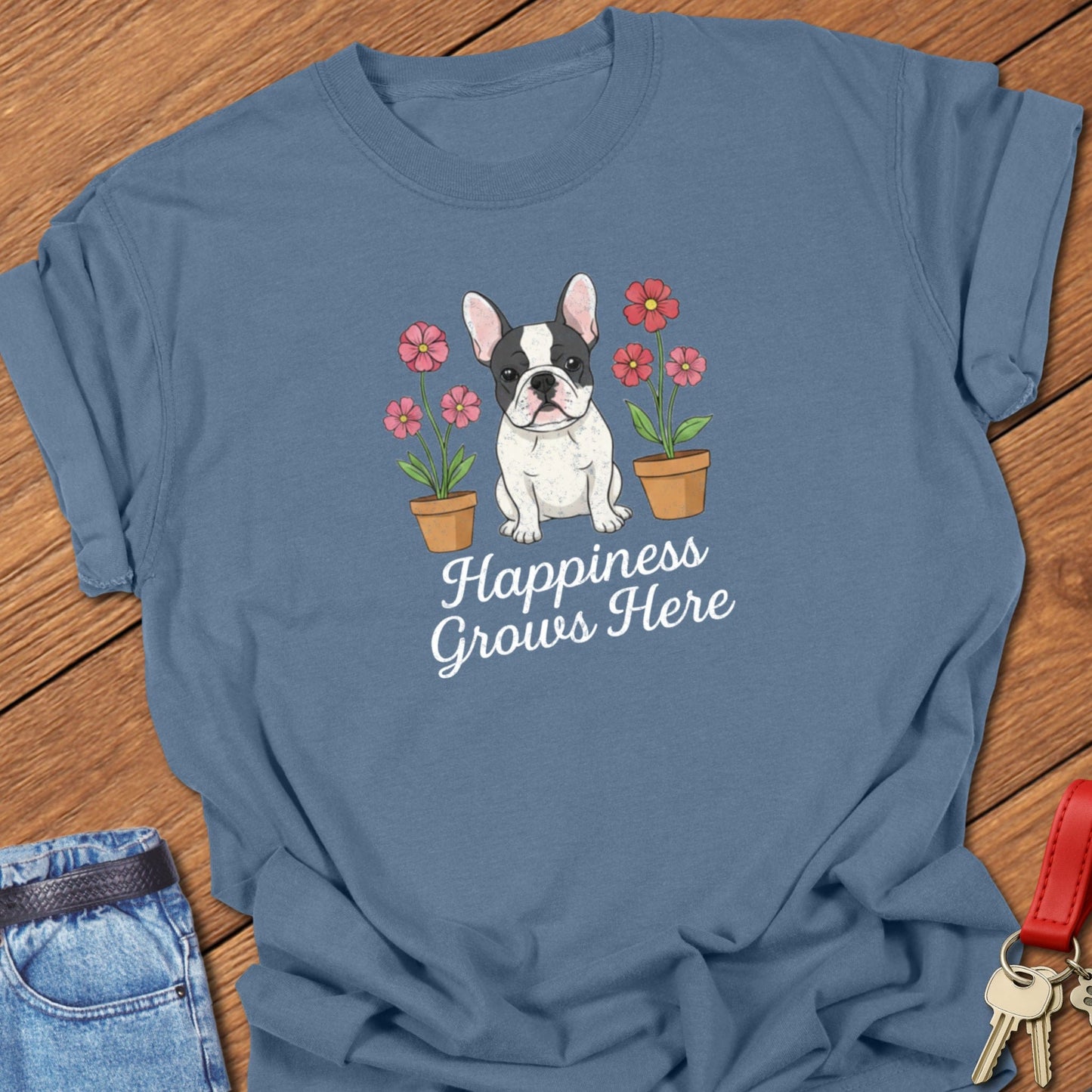 French bulldog illustrated puppy with flowers and “Happiness Grows Here” text printed on blue jean Comfort Colors t shirt