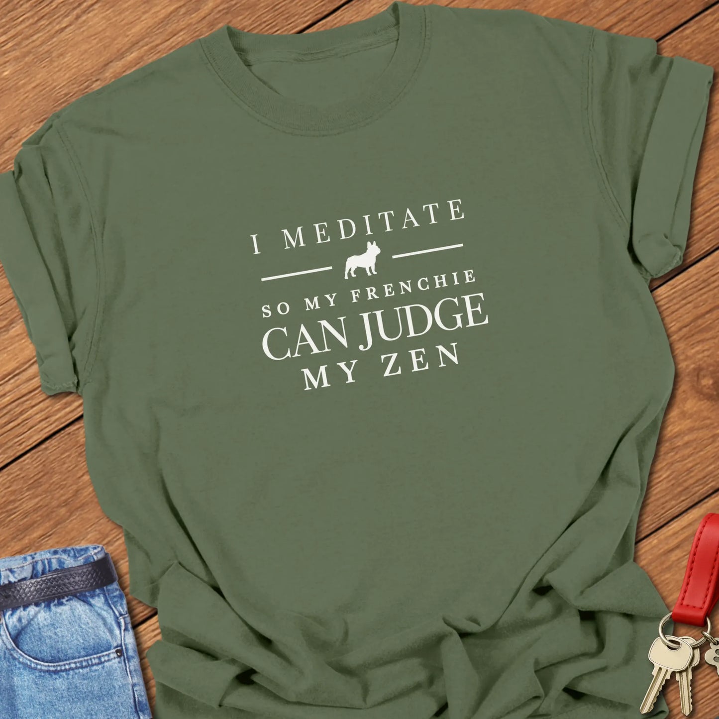 I Meditate So My Frenchie Can Judge My Zen text design featuring a French Bulldog silhouette on a Comfort Colors 1717 t shirt in Moss color.