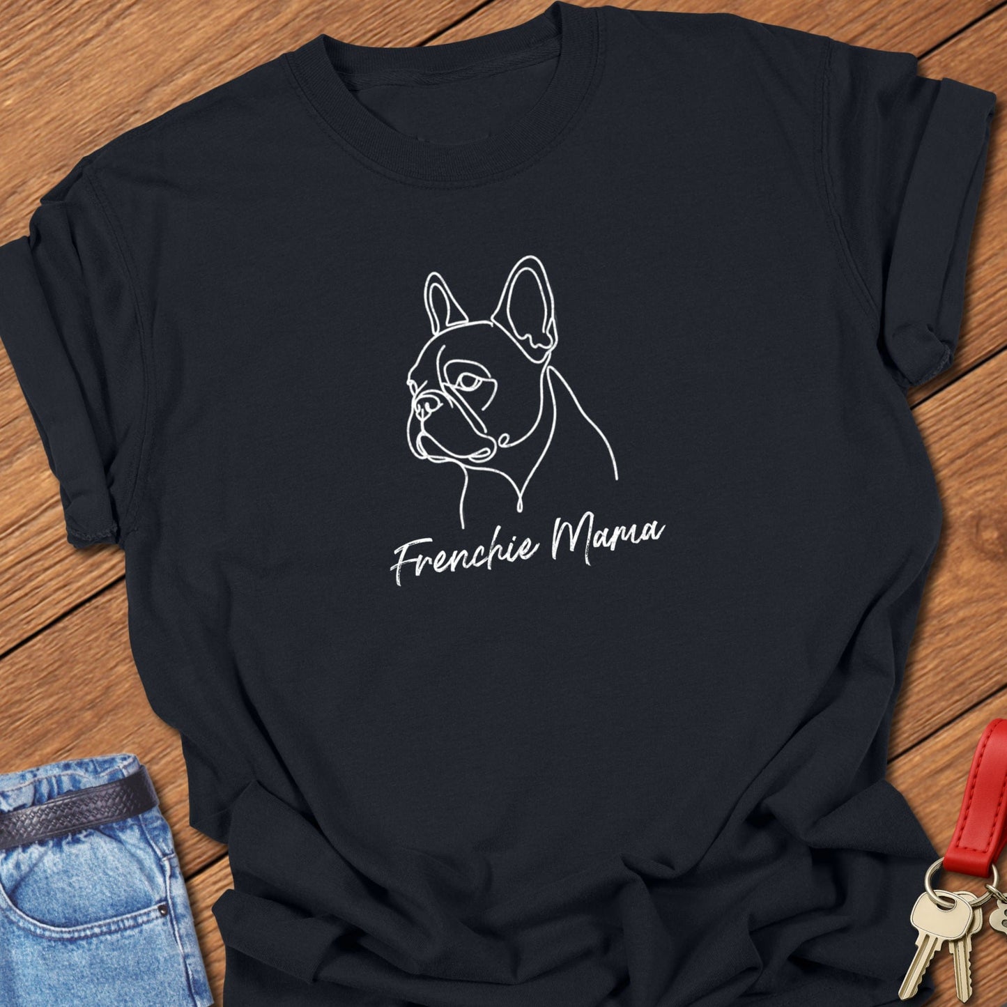 French bulldog minimalist line art portrait with “Frenchie Mama” script text printed on black Comfort Colors t shirt.