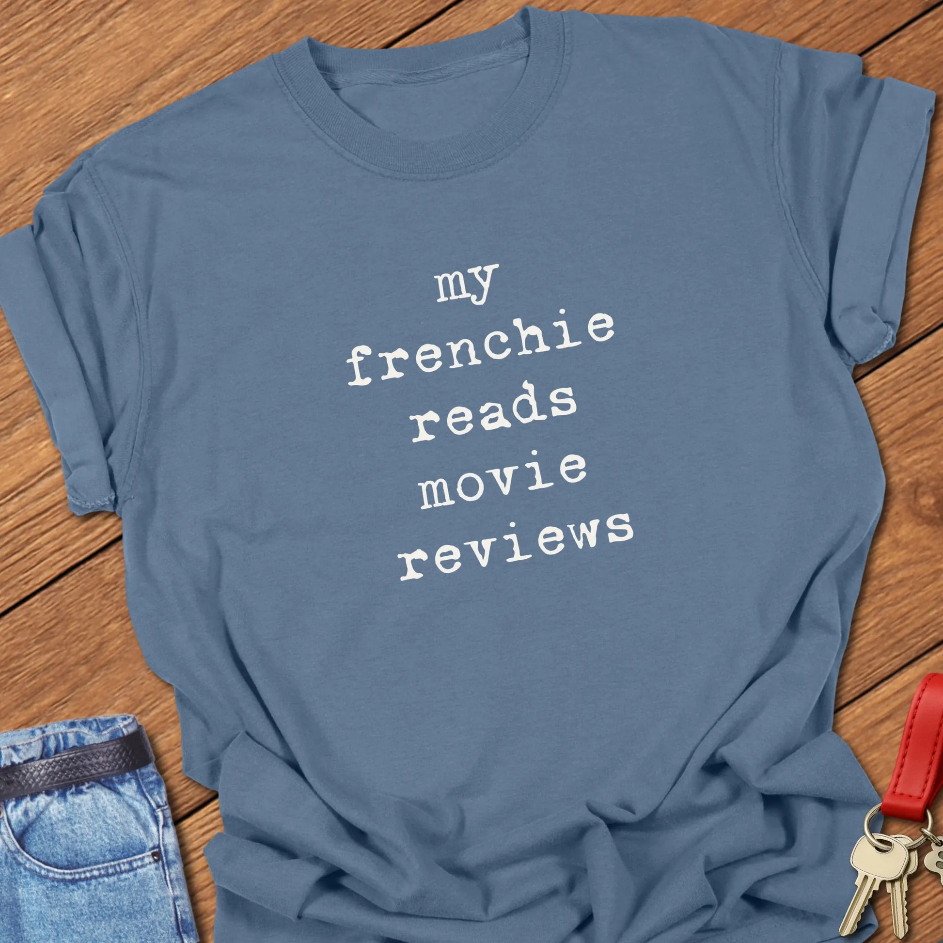 French Bulldog t-shirt featuring the slogan "My Frenchie Reads Movie Reviews" printed on a Comfort Colors® garment-dyed t-shirt in Blue Jean color.