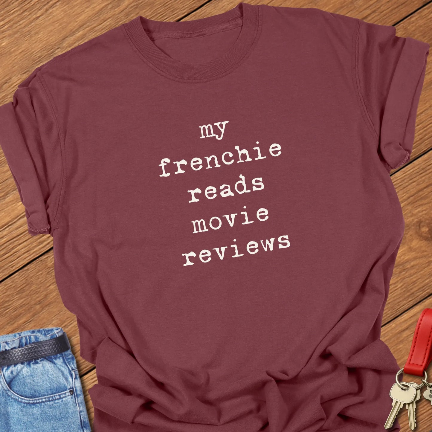 French Bulldog t-shirt featuring the slogan "My Frenchie Reads Movie Reviews" printed on a Comfort Colors® garment-dyed t-shirt in Brick color.
