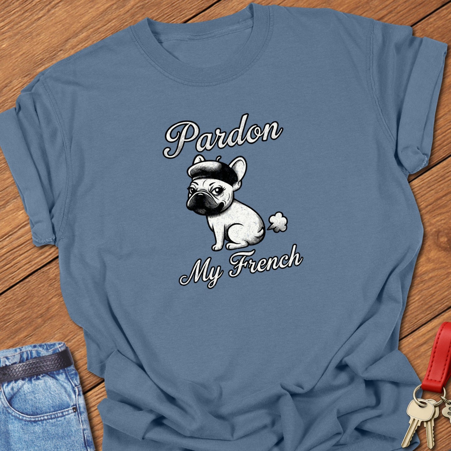 French bulldog illustrated wearing a beret with “Pardon My French” typography printed on blue jean Comfort Colors t shirt