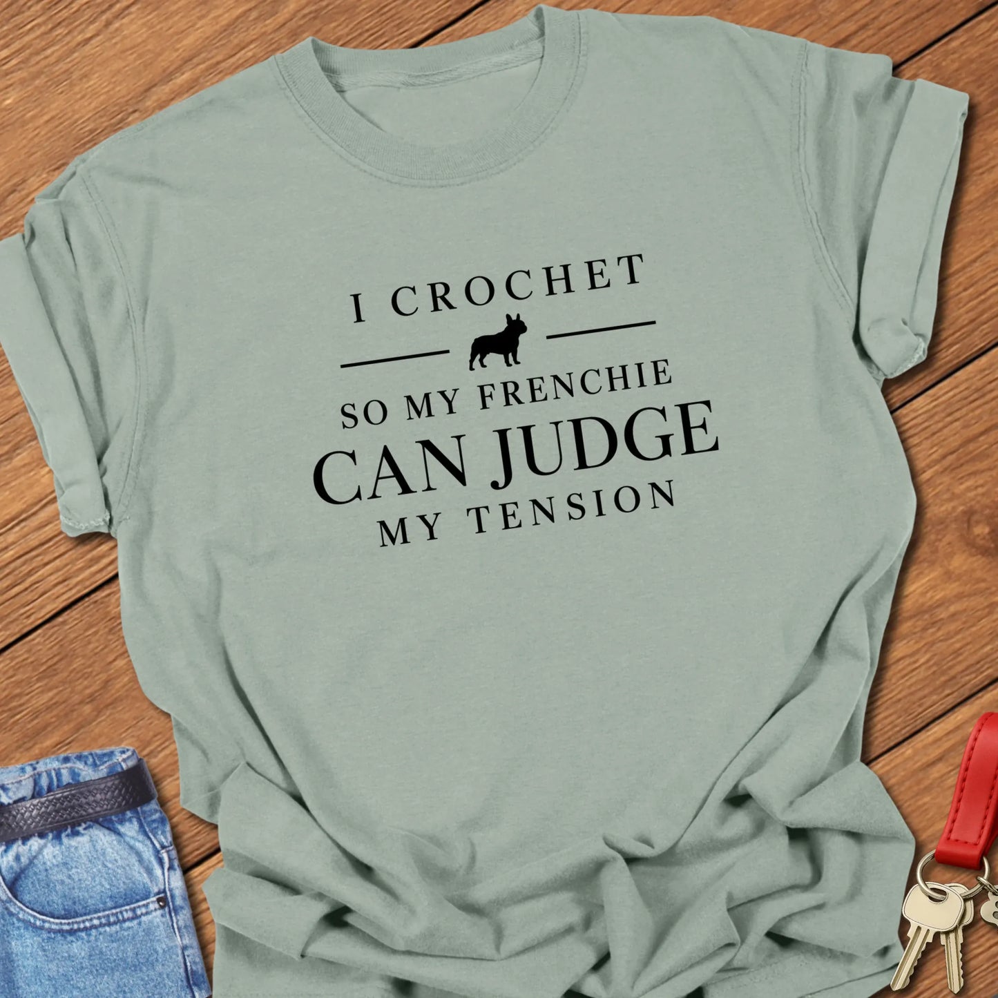 I Crochet So My Frenchie Can Judge My Tension text design featuring a French Bulldog silhouette on a Comfort Colors 1717 t shirt in Bay color.