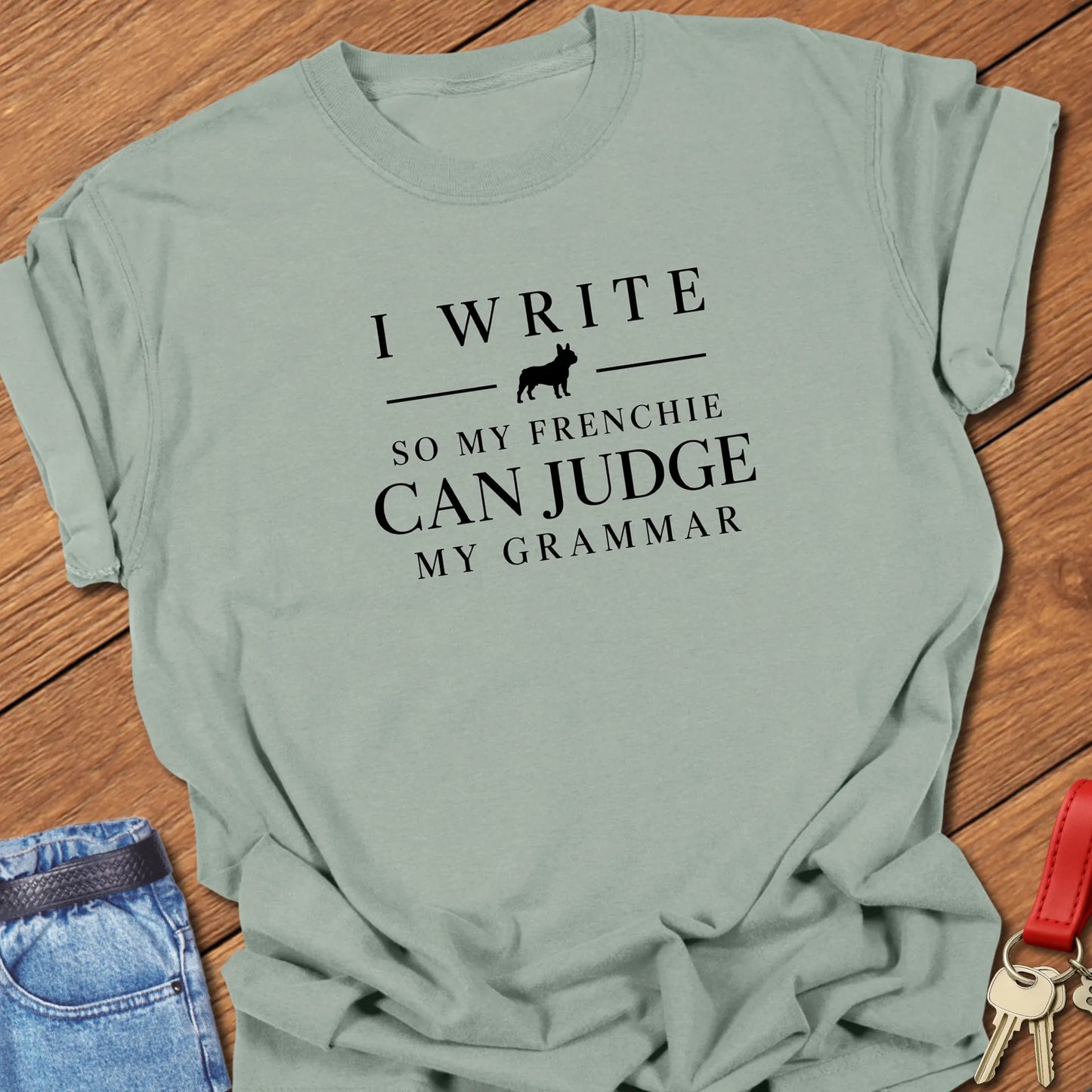 I Write So My Frenchie Can Judge My Grammar text design along with a French Bulldog silhouette on a Comfort Colors 1717 t shirt in Bay color.
