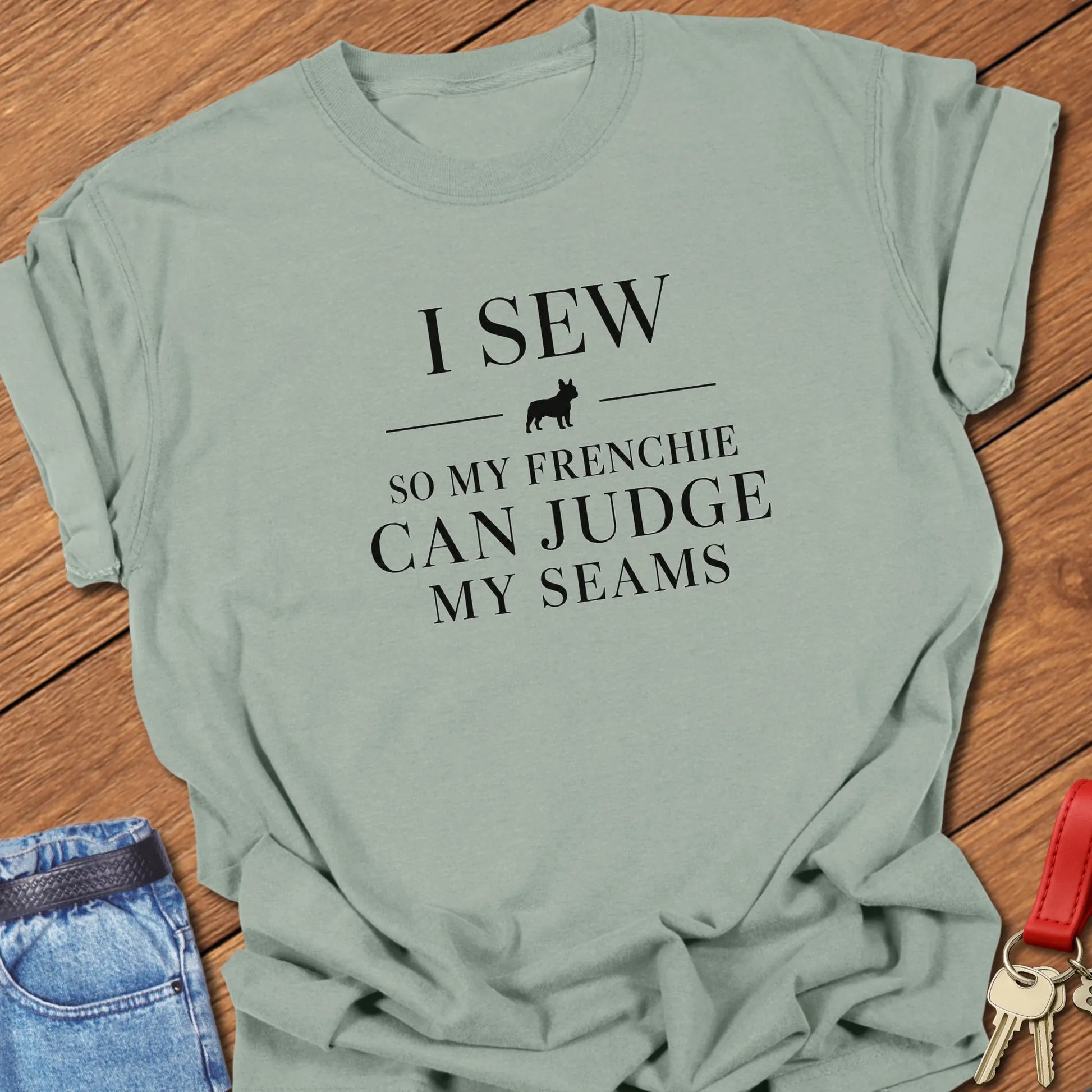 I Sew So My Frenchie Can Judge My Seams text design along with a French Bulldog silhouette on a Comfort Colors 1717 t shirt in Bay color.