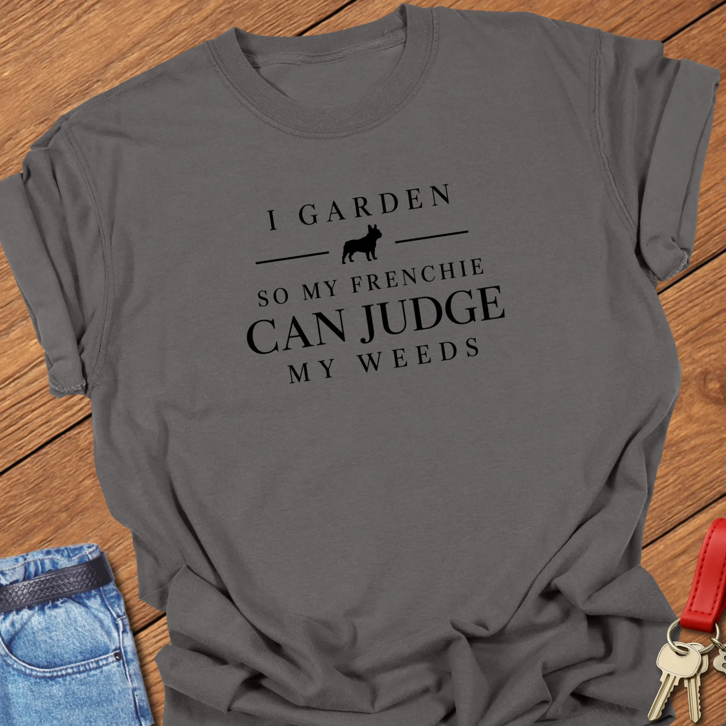 I Garden So My Frenchie Can Judge My Weeds text design along with a French Bulldog silhouette on a Comfort Colors 1717 t shirt in Pepper color.