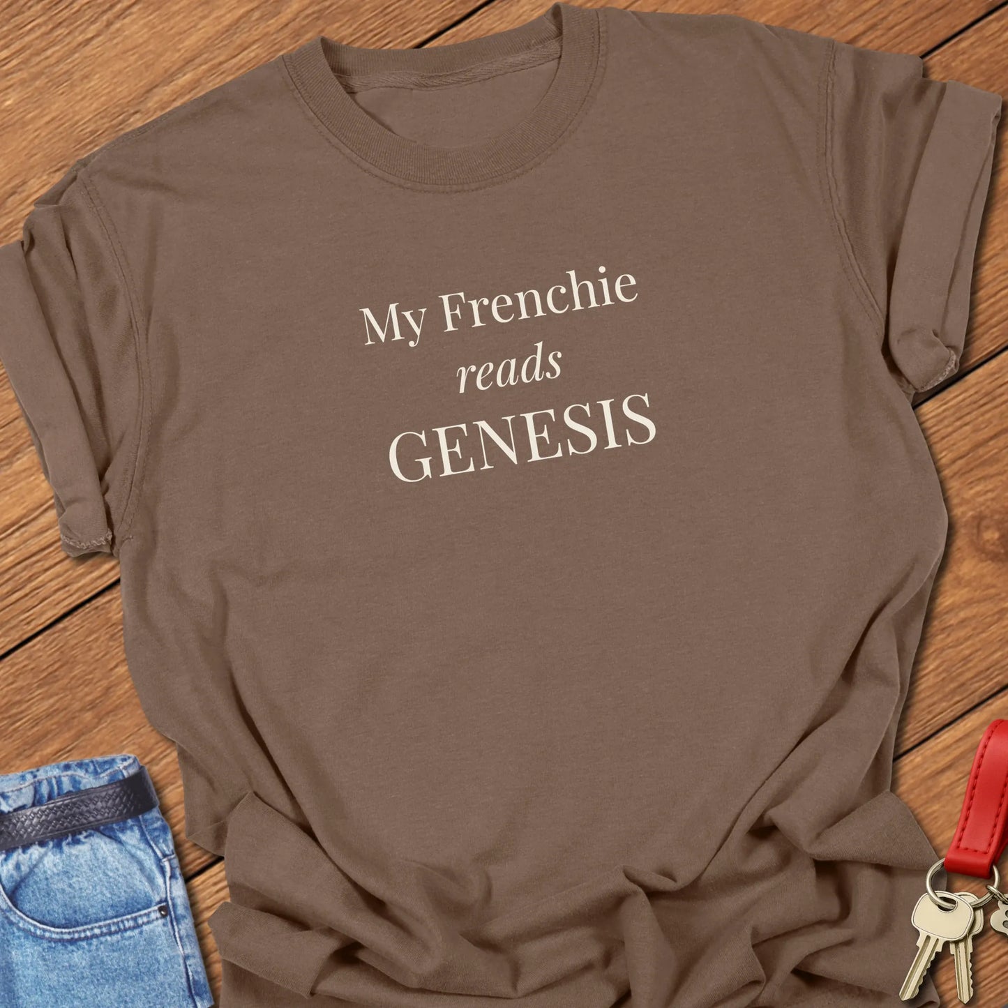My Frenchie Reads Genesis French Bulldog t-shirt displayed on an Espresso Comfort Colors® garment-dyed shirt featuring elegant serif typography.