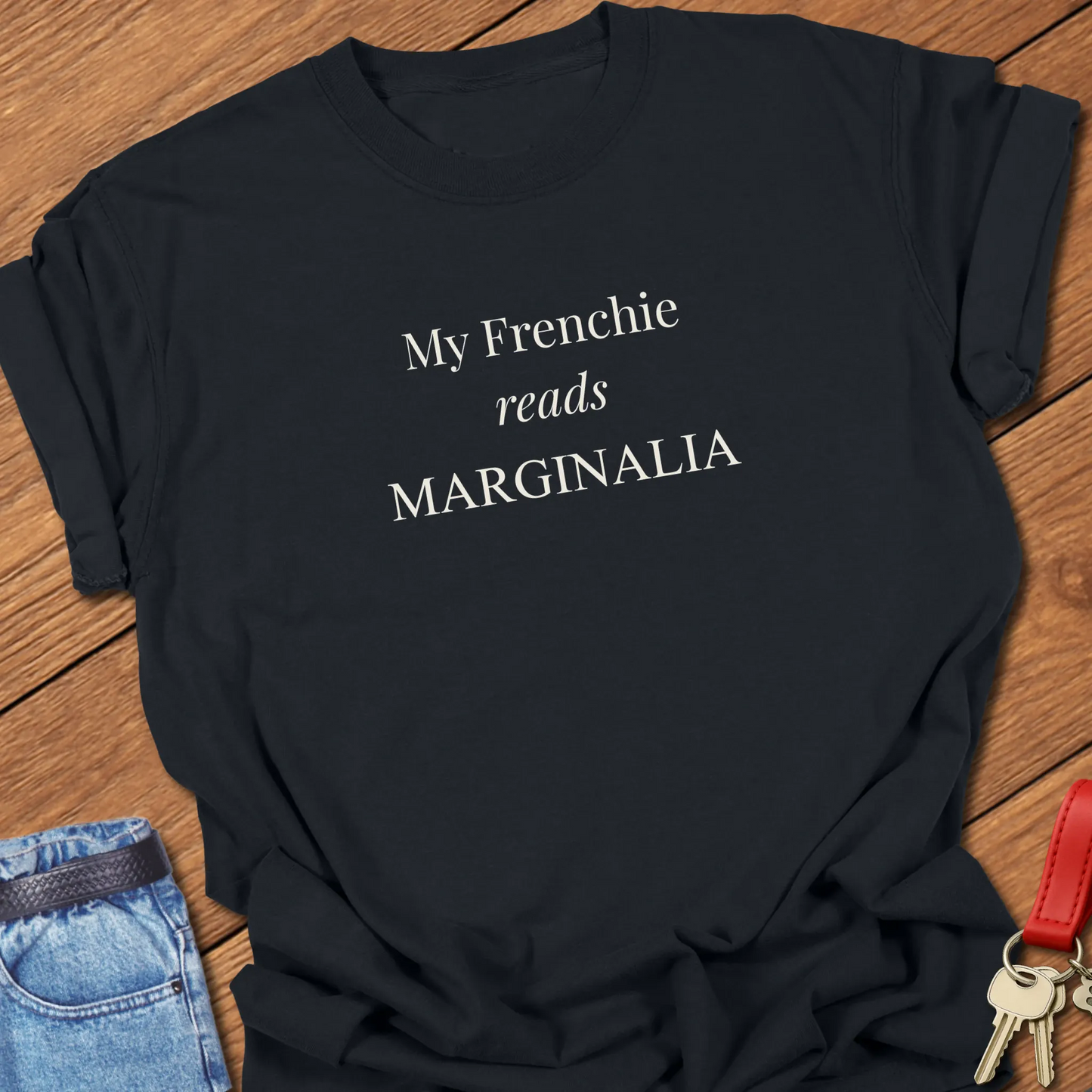 Reads Marginalia T Shirt featuring the phrase "My Frenchie Reads Marginalia" in elegant ivory typography on a Comfort Colors 1717 shirt in Black Color.