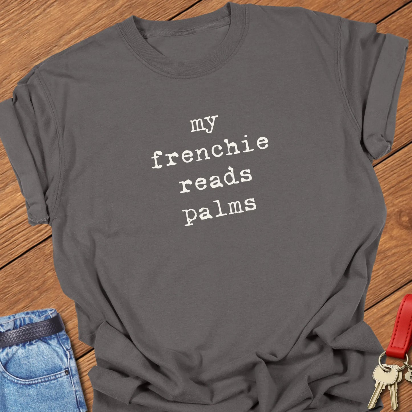 Typewriter-style typography featuring the slogan "My Frenchie Reads Palms" printed on a Comfort Colors® garment-dyed t-shirt in Pepper color.