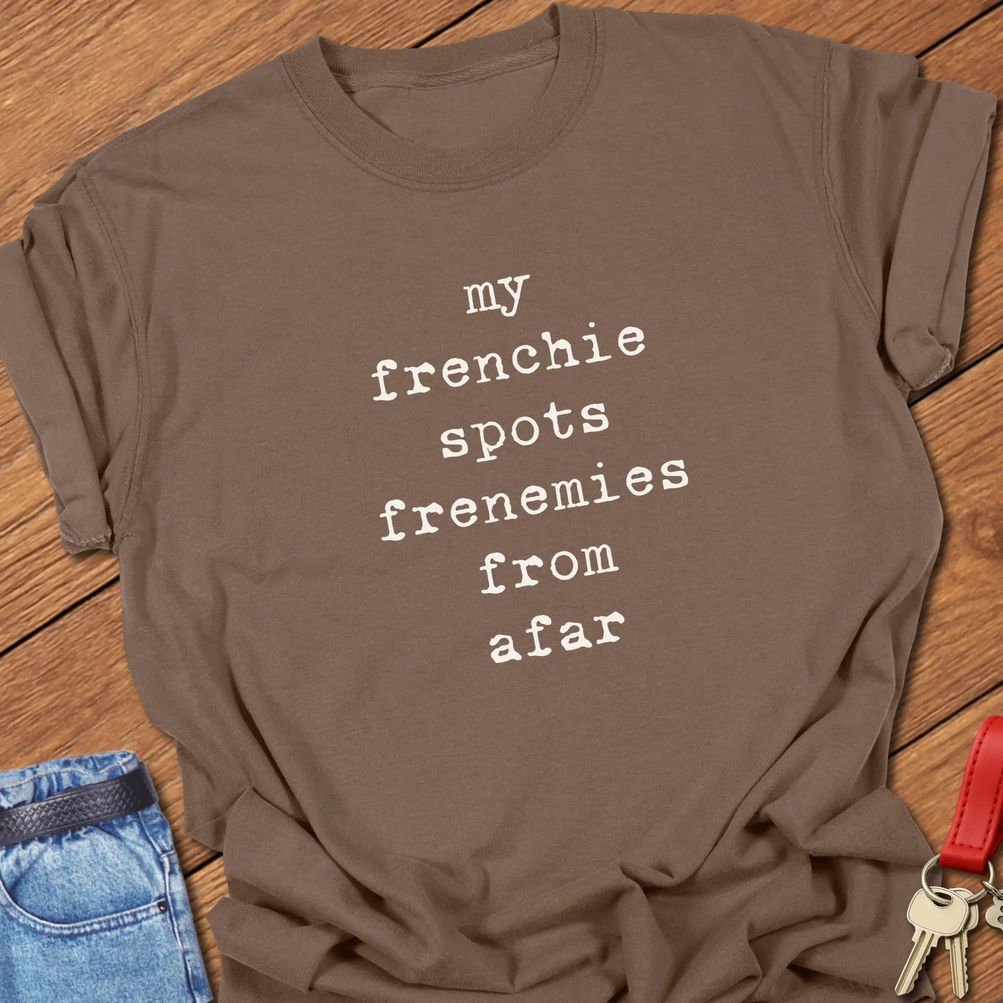 Typewriter-style typography featuring the slogan "My Frenchie Spots Frenemies From Afar" printed on a Comfort Colors® garment-dyed t-shirt in Espresso color.
