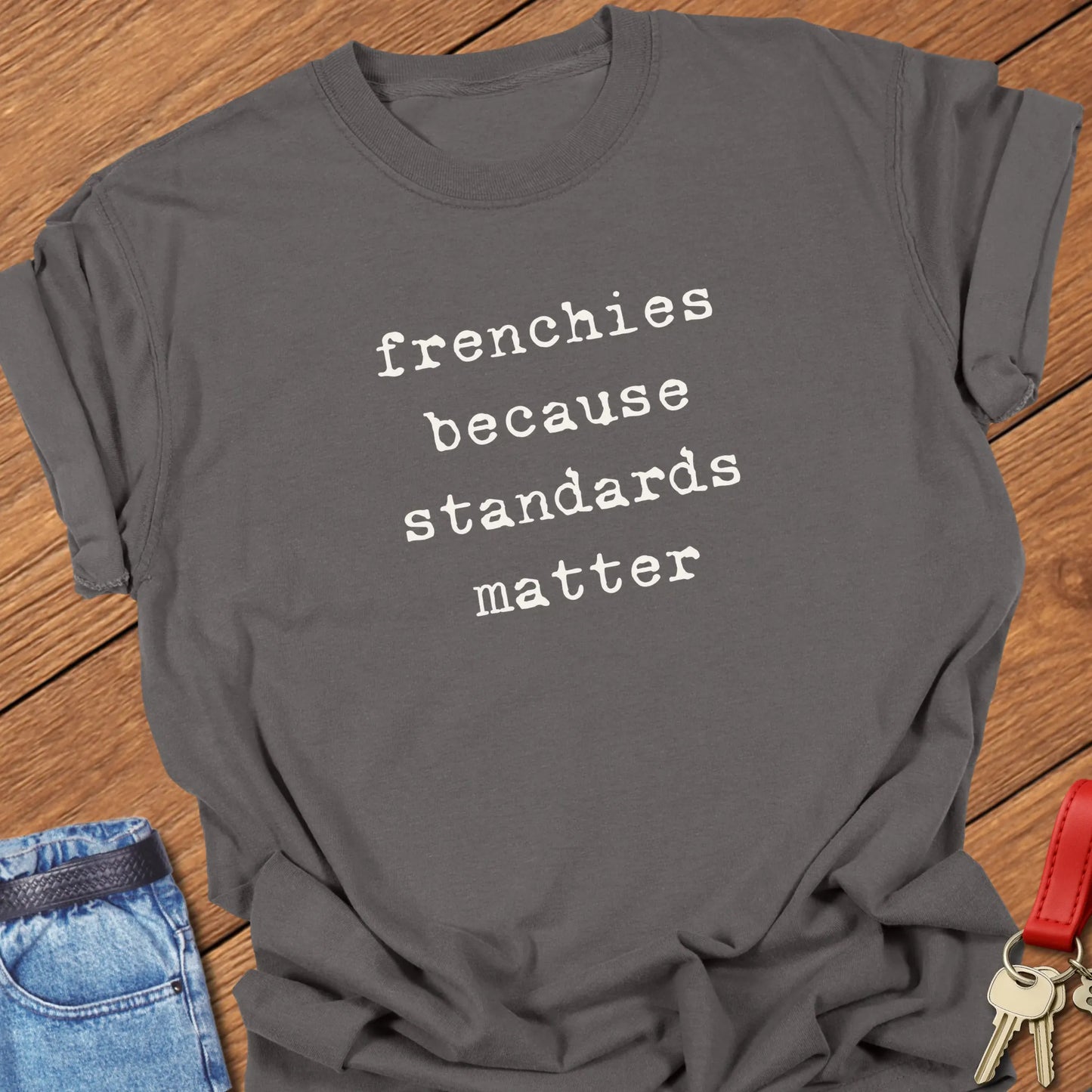 Typewriter-style typography featuring the slogan "Frenchies Because Standards Matter" printed on a Comfort Colors® garment-dyed t-shirt in Pepper color.